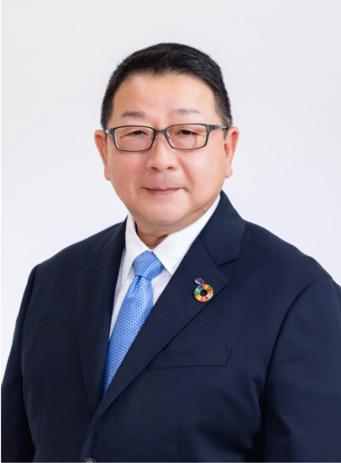 sugiura-img スーツを着た会長が正面を向いて微笑んでいる写真